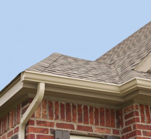 House roof gutters and downspout on the corner of a house.